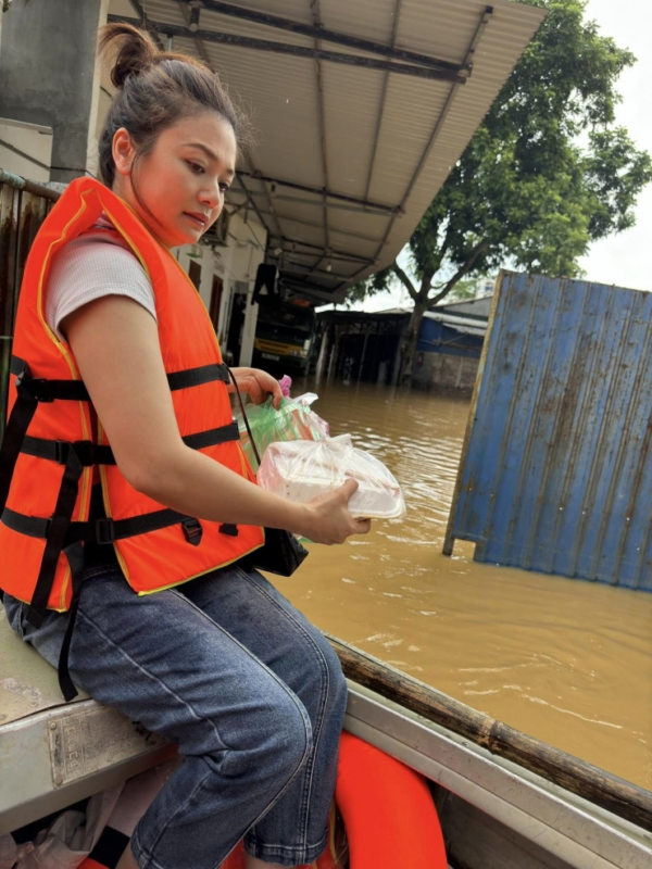 Diễn viên Kiều Anh đi thuyền tới các nhà dân bị cô lập để phát lương thực. 